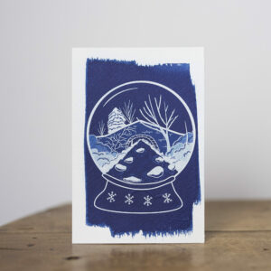 carte postale cyanotype thème hiver, boule à neige avec rivière et pont